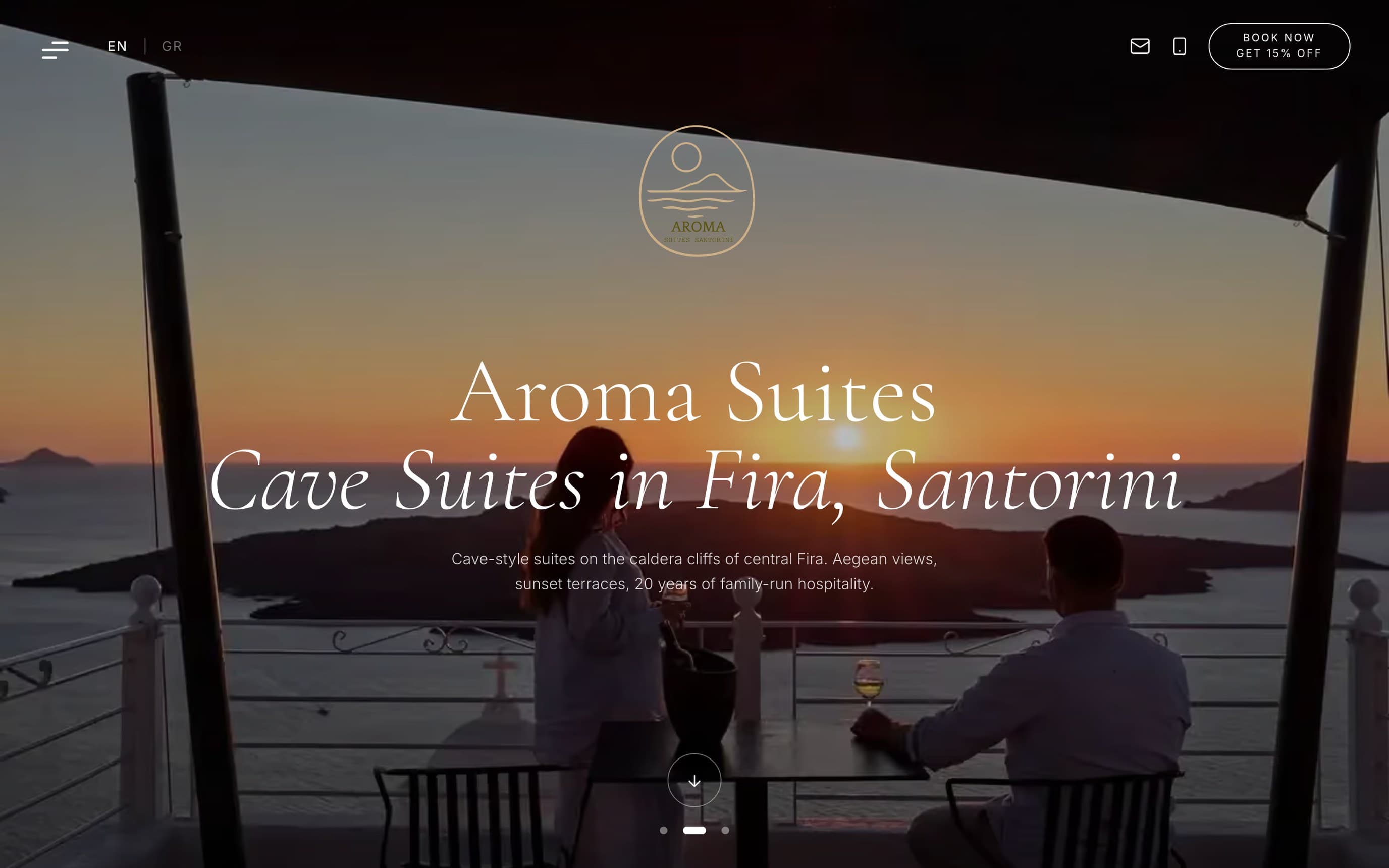 Η αρχική σελίδα του aromasuites.com σε υπολογιστή: βεράντα με θέα την καλντέρα στο ηλιοβασίλεμα, ο τίτλος «Cave Suites in Fira, Santorini», επιλογή γλώσσας EN/GR πάνω αριστερά και κουμπί «Book now» πάνω δεξιά